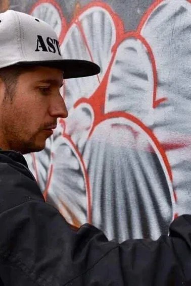 Artiste graffeur peignant une fresque murale colorée.