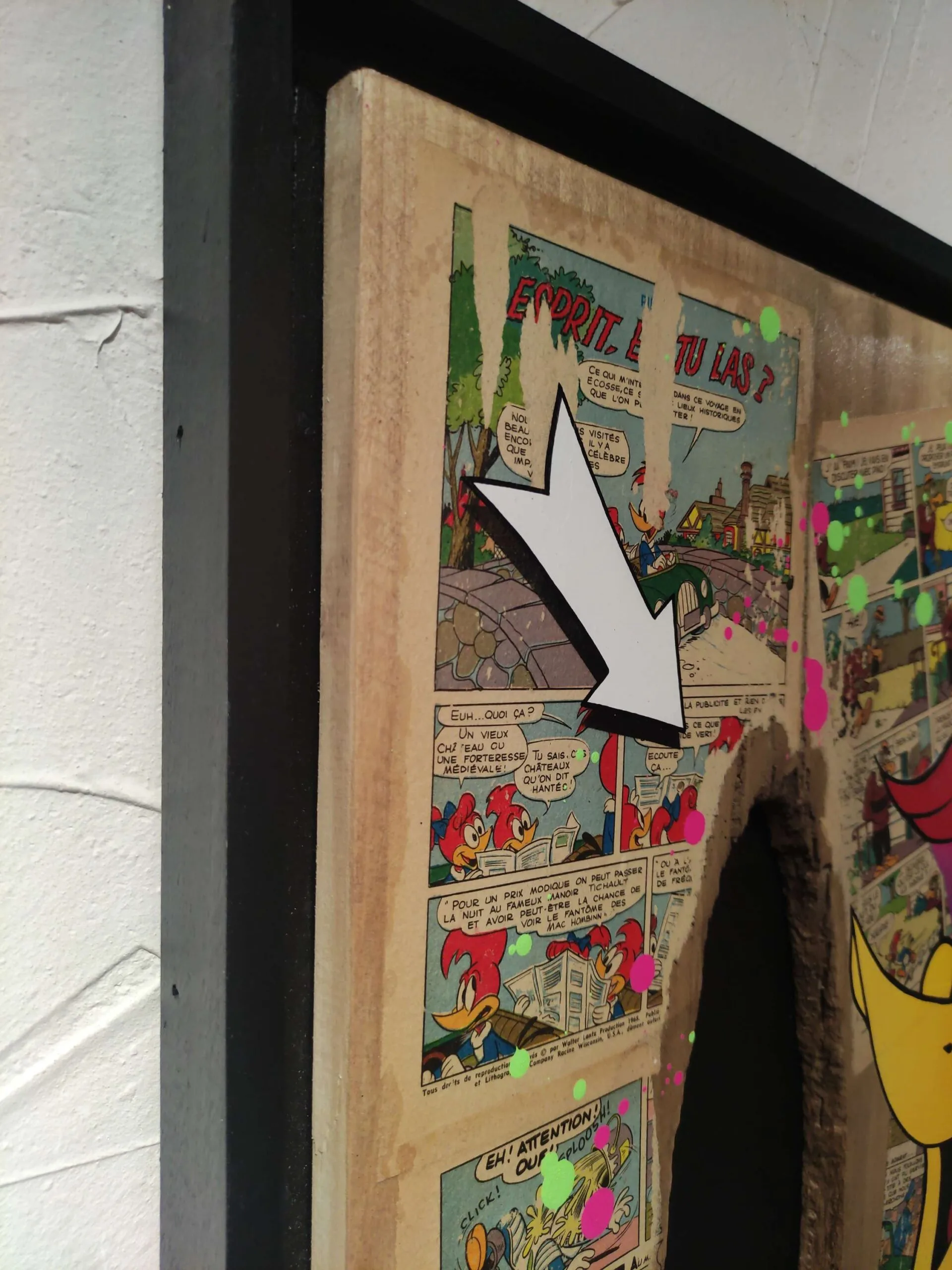 Bande dessinée colorée avec flèche blanche sur cadre bois.
