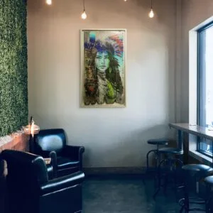 Coin salon avec fauteuils et peinture murale colorée.