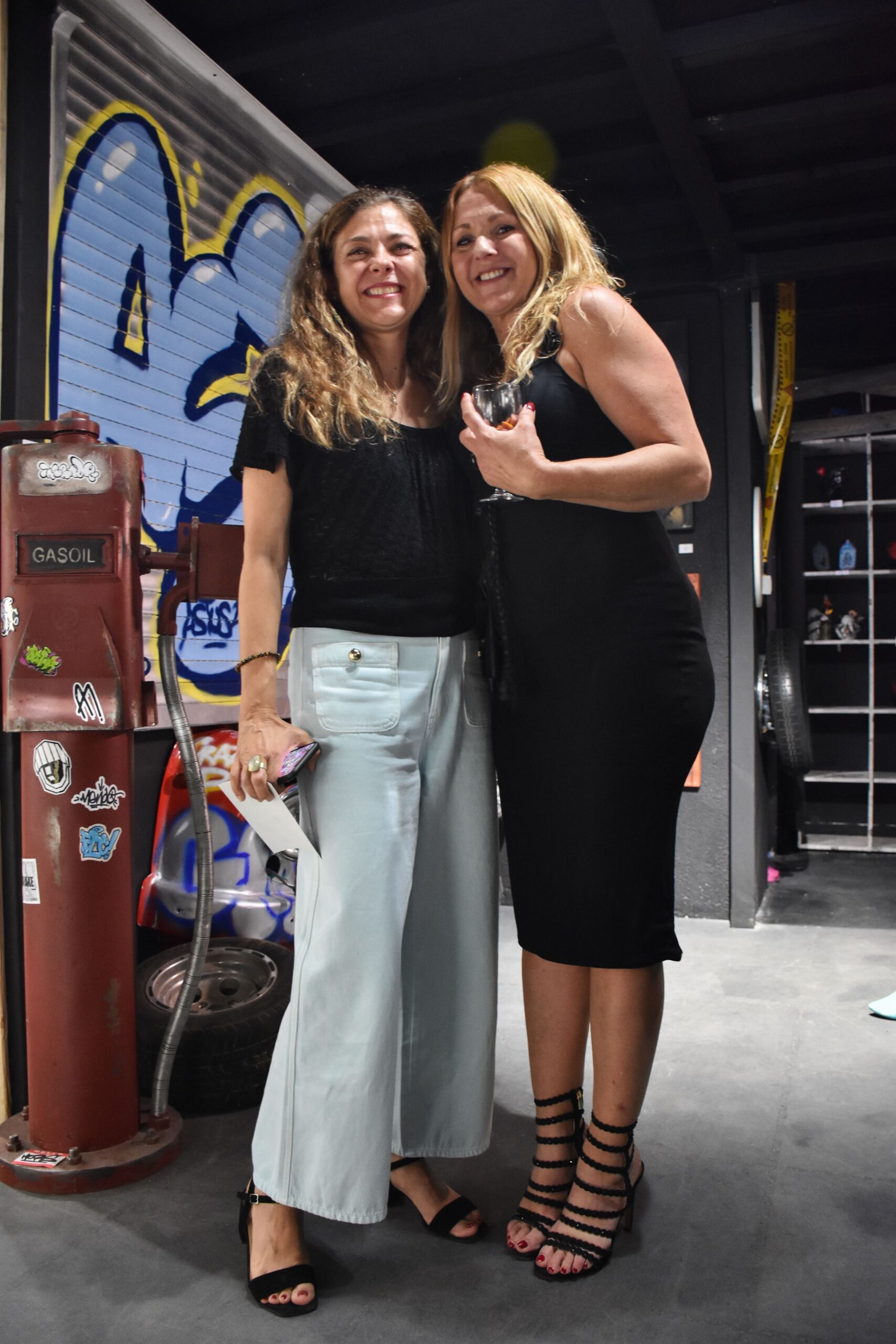 Deux femmes souriantes lors d'une soirée élégante.