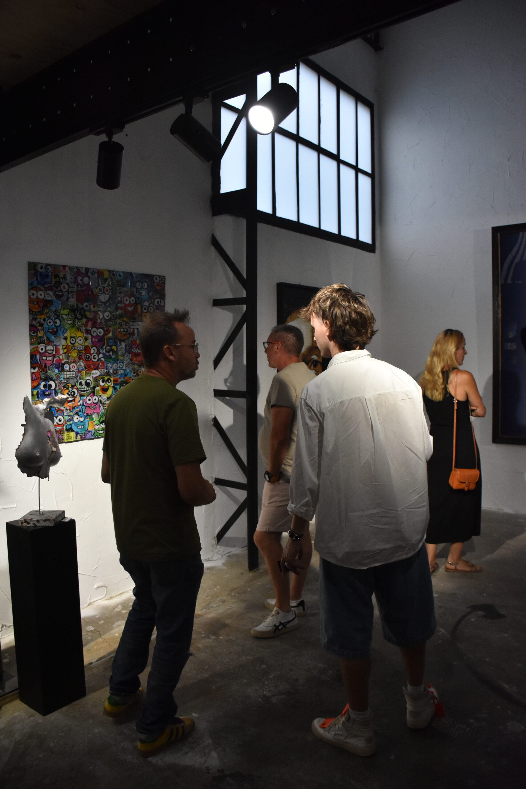 Visiteurs discutant dans une galerie d'art moderne.