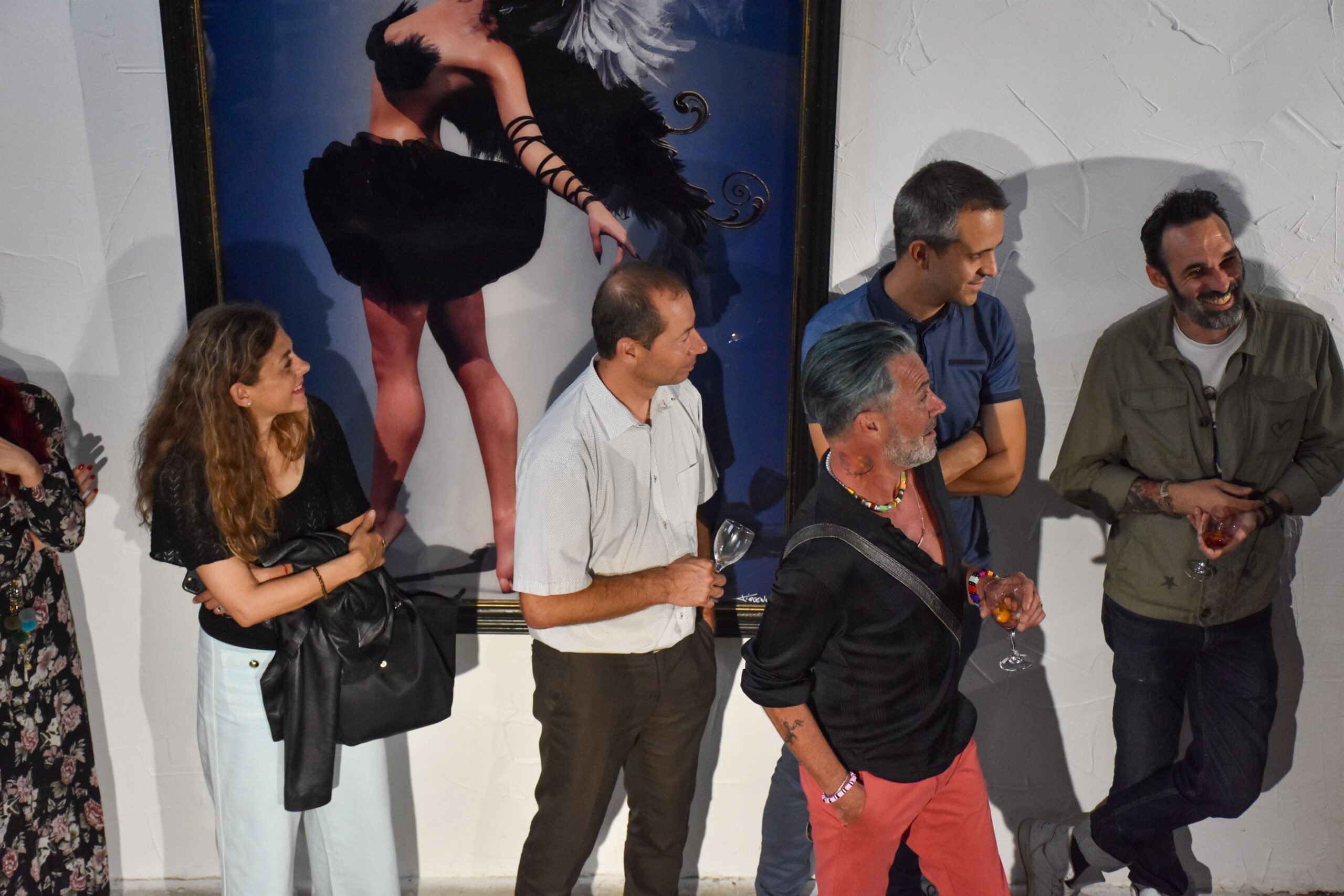 Groupe de personnes devant une œuvre lors d'une exposition.