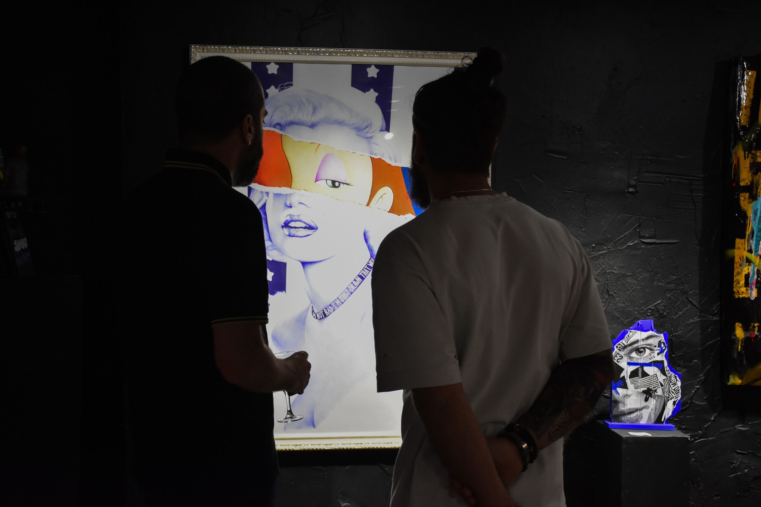 Deux hommes observent une œuvre d'art moderne.