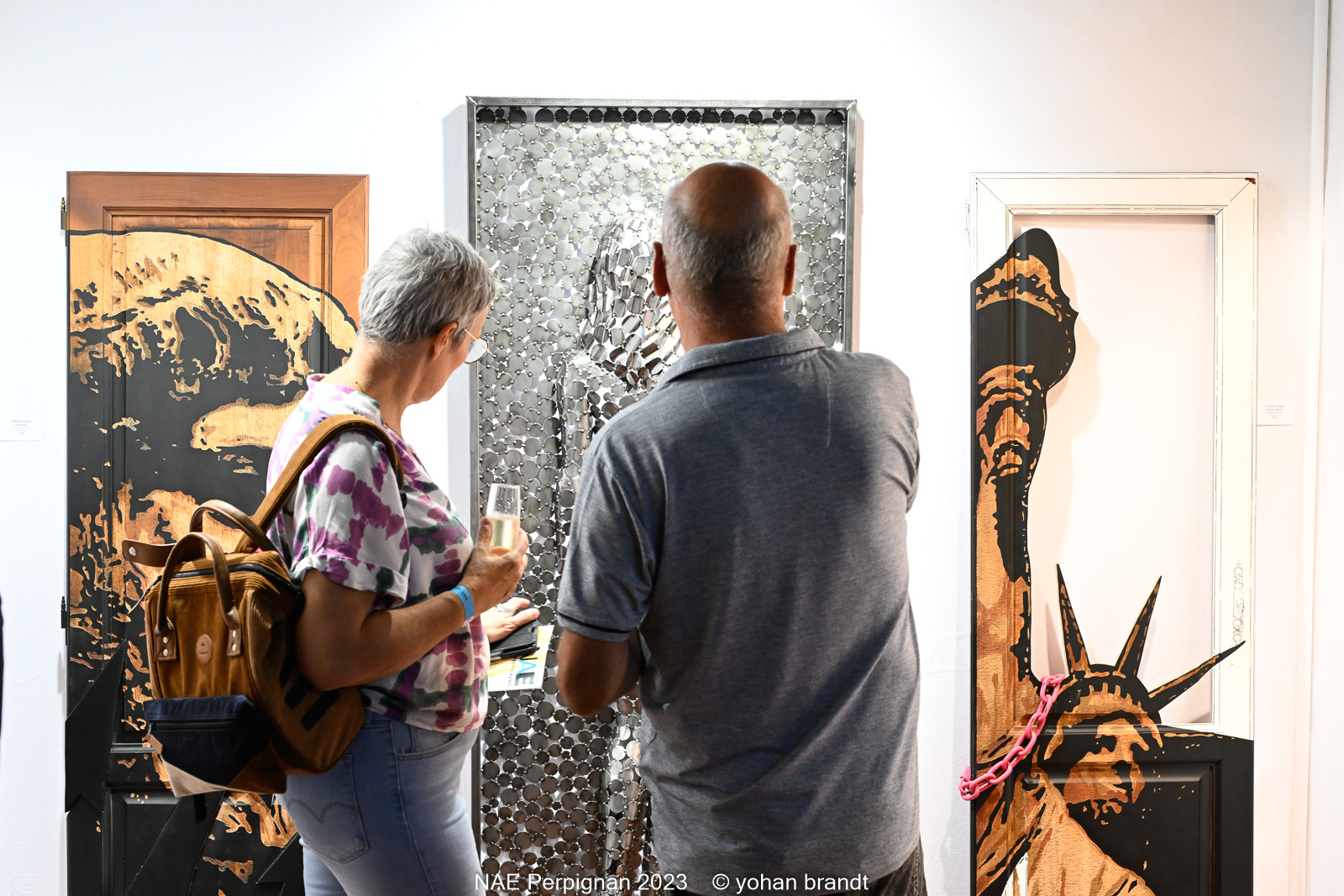 Visiteurs admirant art moderne en galerie.