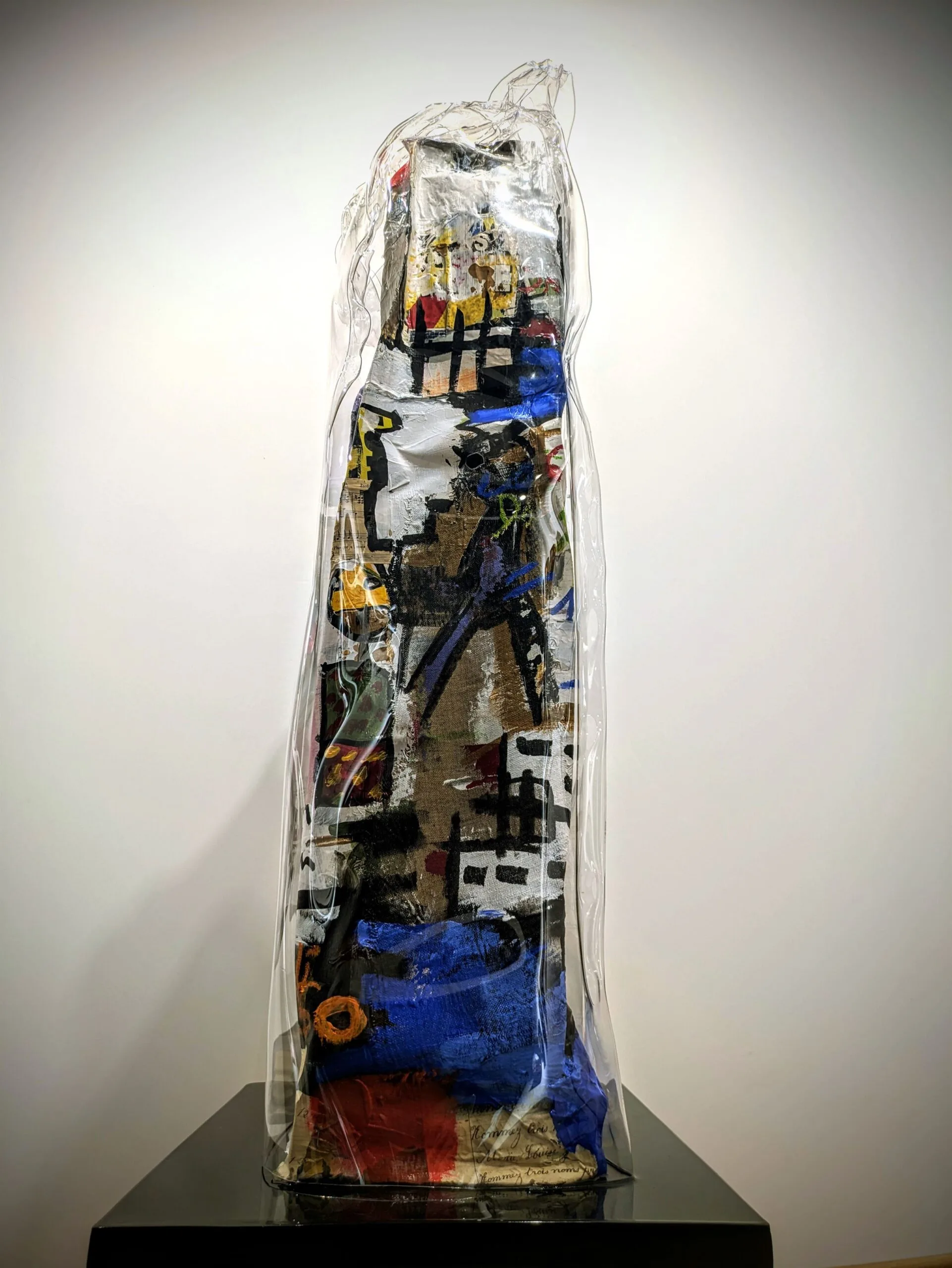 Sculpture abstraite colorée protégée par du plastique.
